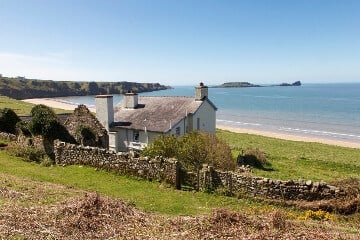 White holiday cottage in a rural location with sea views