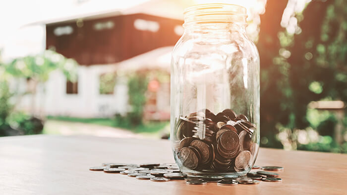 savings jar in front of a house