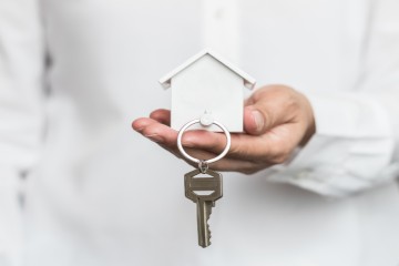 Landlord holding a model house and keys