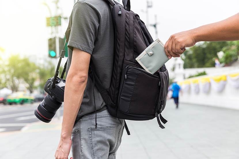 A pickpocket attempting to steal a wallet from someone in broad daylight