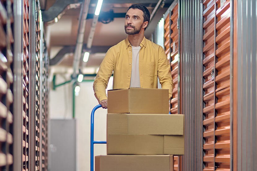 a man carrying boxes into a storage unit