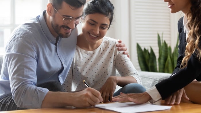 two people signing a form 