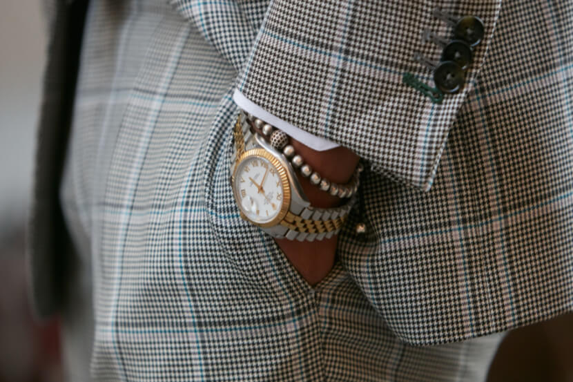 Rolex watch worn on the wrist of a man in rather a natty suit