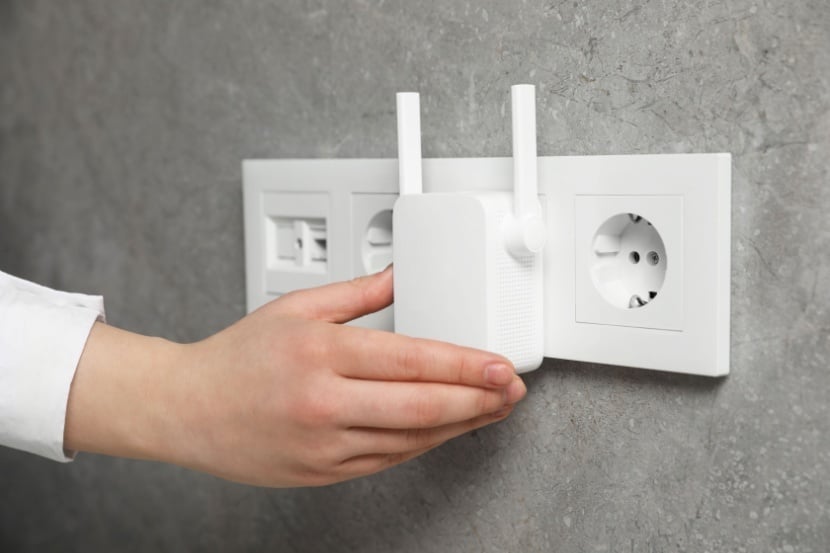 Person inserting Wi-Fi boosters into wall