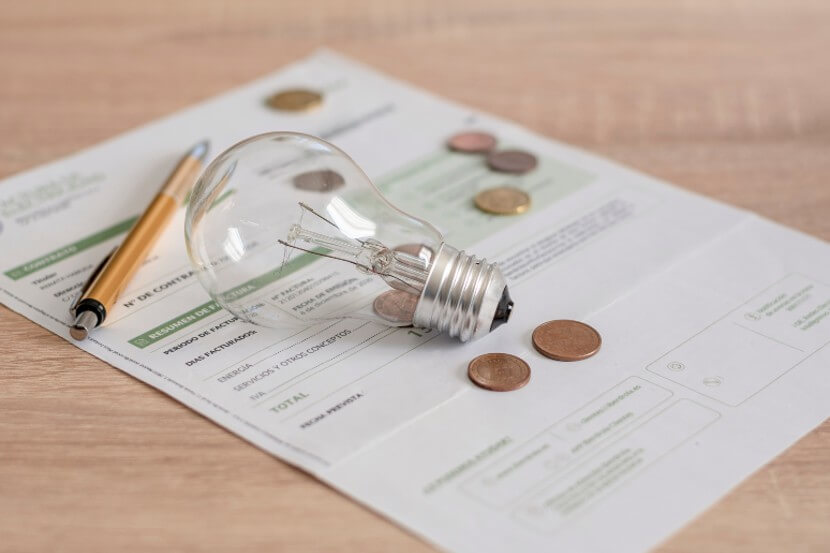 Bill on the table with a lightbulb and pennies