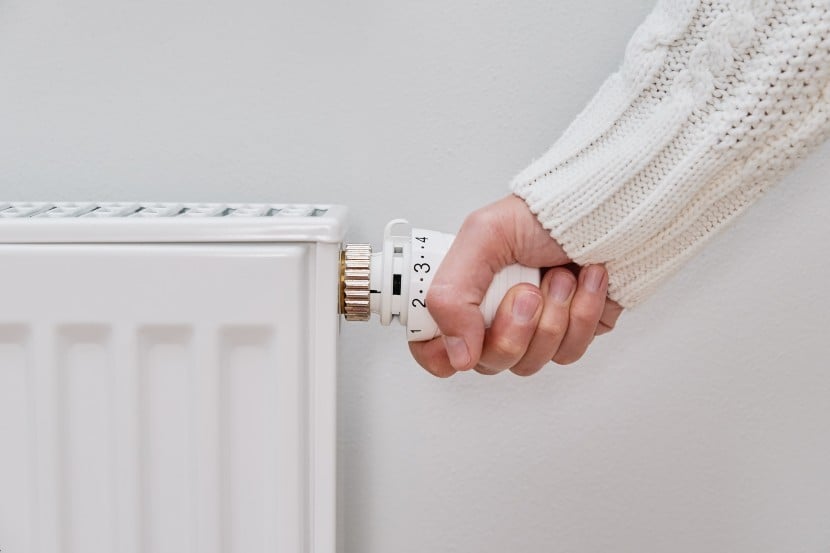 A person adjusting temperature on heating radiator
