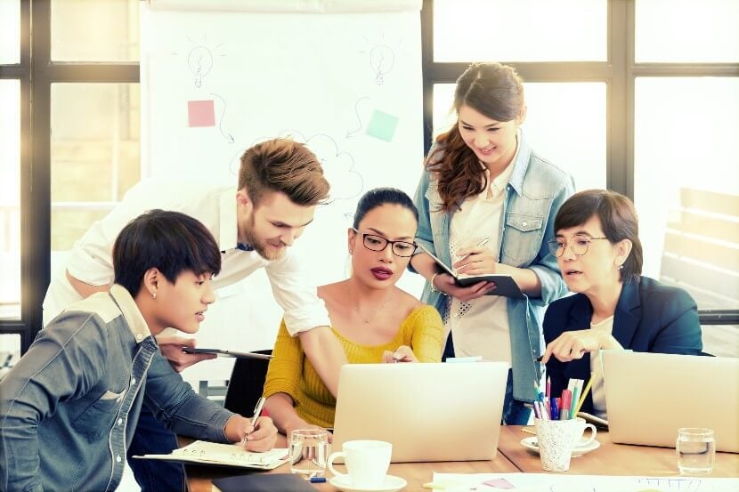 Group of students looking at a laptop together