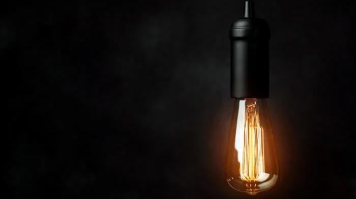 Vintage lightbulb lit in a dark room