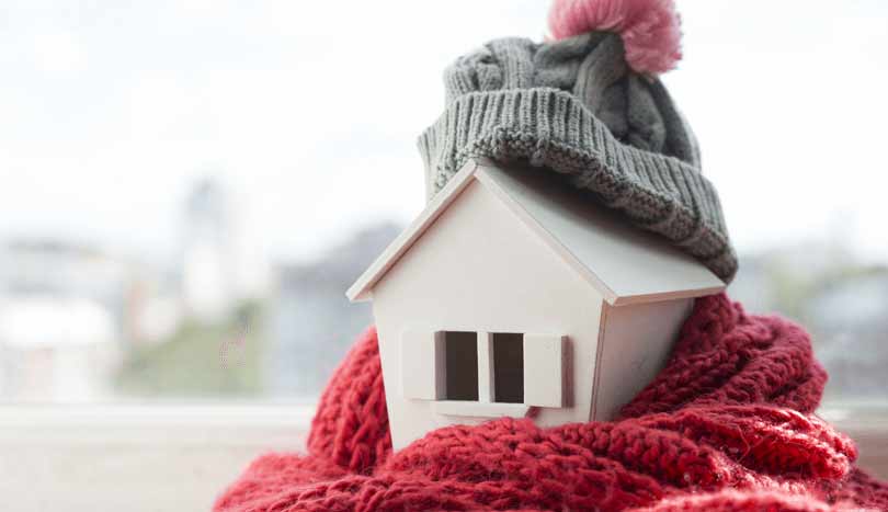 House wrapped in scarf and bobble hat