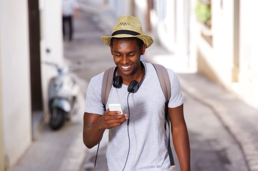 man in hat travelling with mobile phone