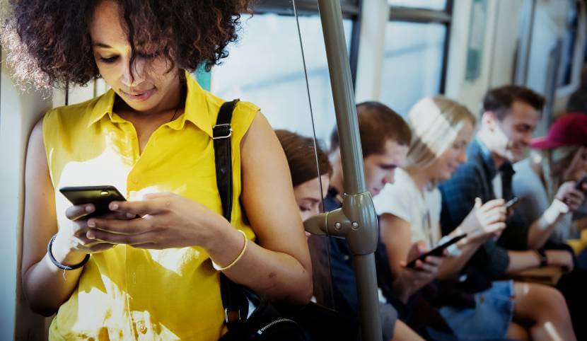 Group of people on a train using their smartphones