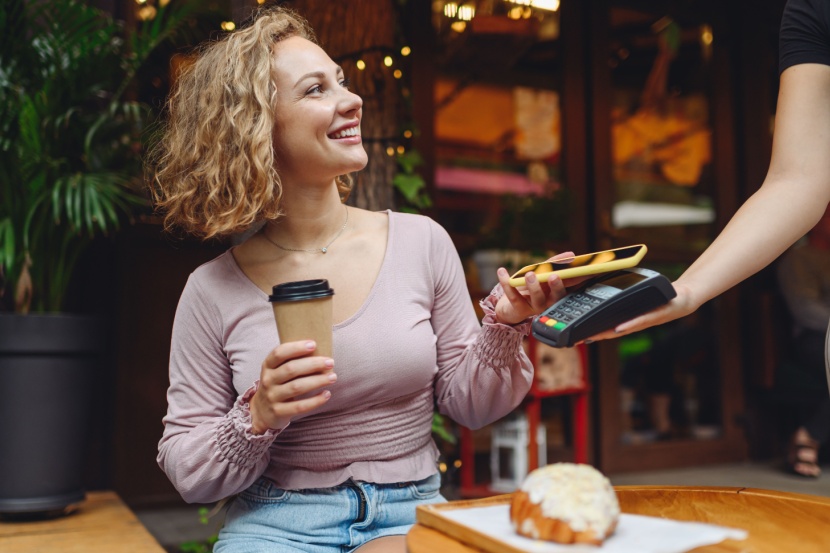woman paying for coffee with mobile phone