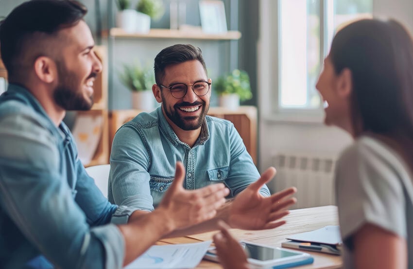 A group of three chatting together at a table
