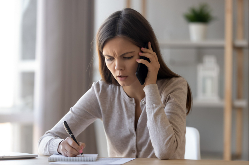 A woman on the phone and writing notes