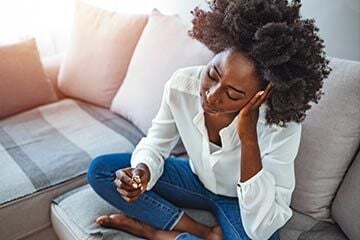 Woman sitting on the sofa thinking about her divorce
