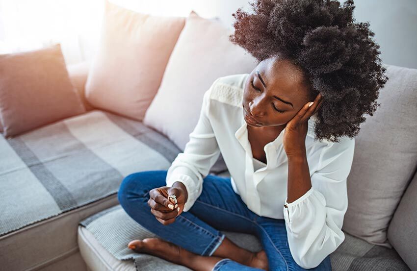 Woman sitting on the sofa thinking about her divorce