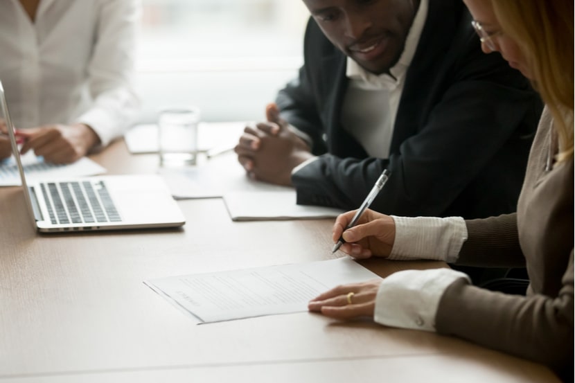 A couple signing a document at a solicitor's office 