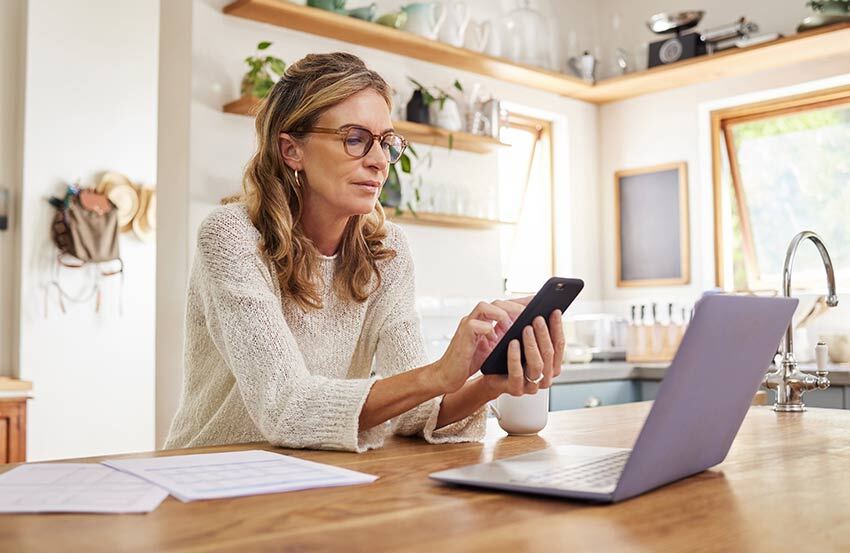 Woman sat at a desk using her mobile phone