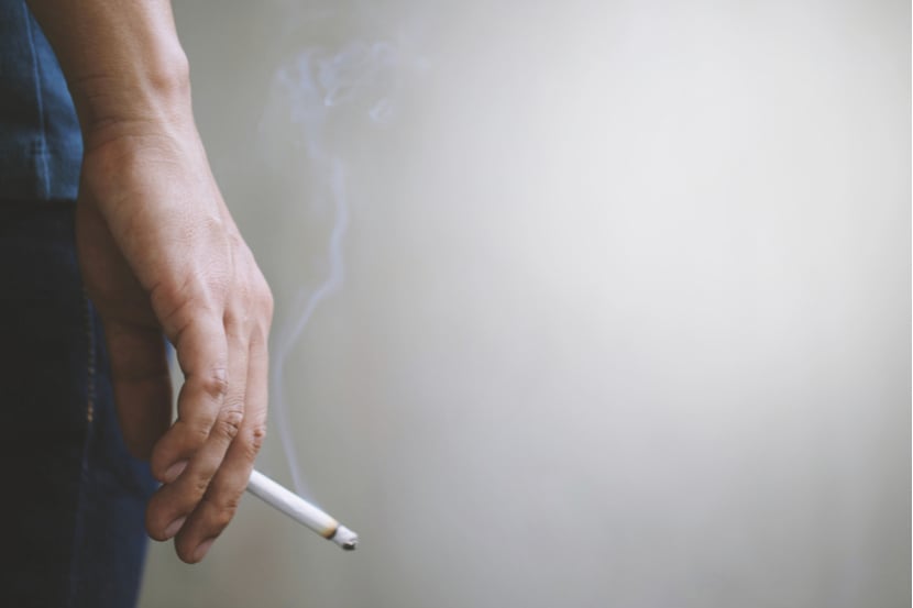 A person holding a cigarette after smoking it