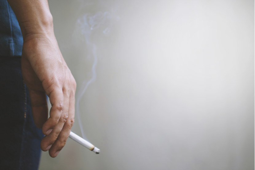 A person holding a cigarette after smoking it