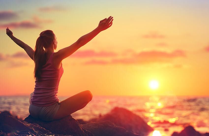 Woman doing yoga at sunset
