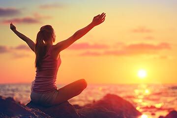 Woman doing yoga at sunset