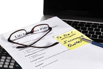 A life insurance policy is printed out with a stick note on top encouraging reader to get life insurance quotes