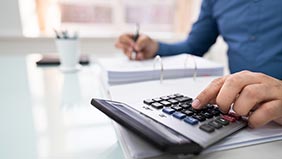 Person using a calculator while working out their budget