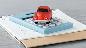 Red toy car on a calculator