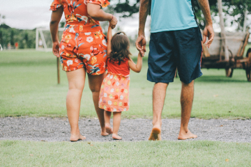 image showing the back of a family walking together inthe summer 