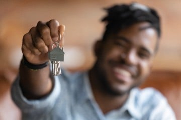 Person looking happy with keys to new home