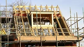 A house being built, surrounded by scaffolding