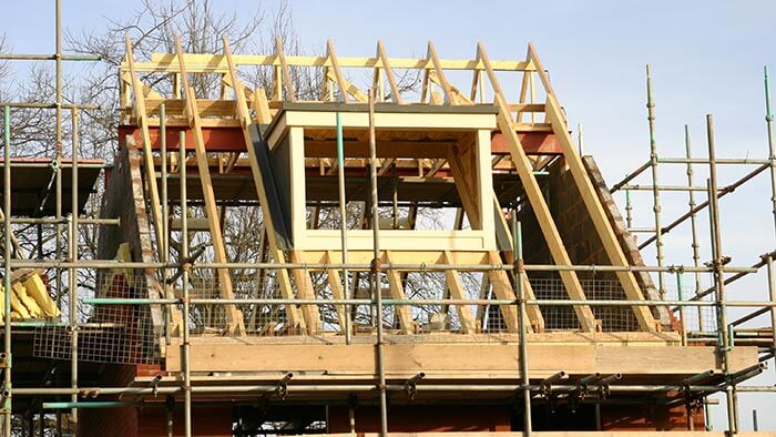 A house being built, surrounded by scaffolding