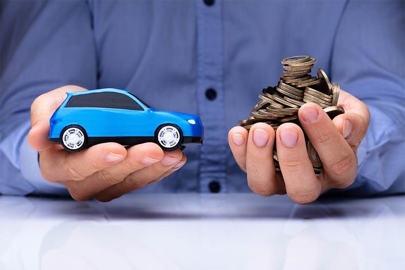 Hands holding a car and coins