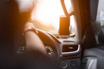 Person driving with phone holder