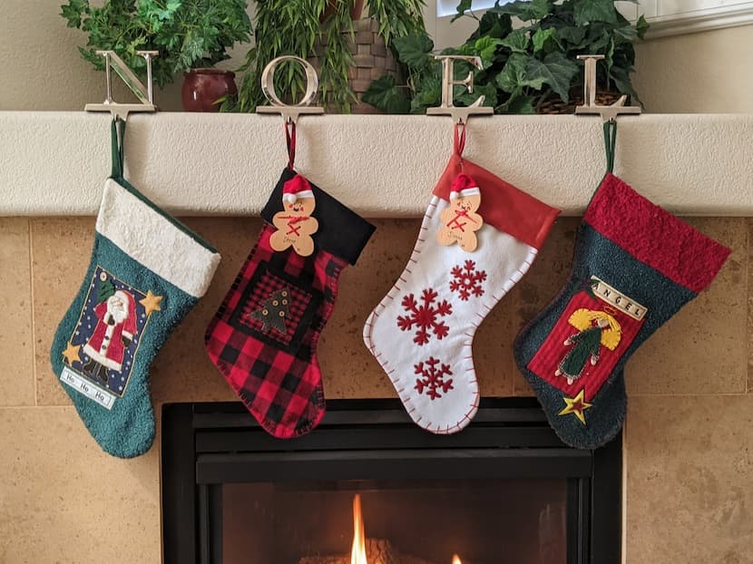 A fireplace with four Christmas stockings hanging on it 