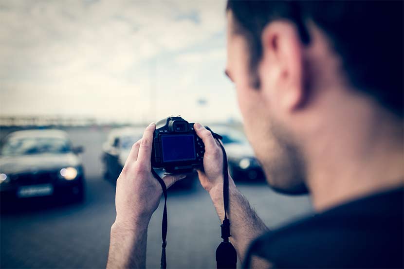  Man takes photograph of cars with camera