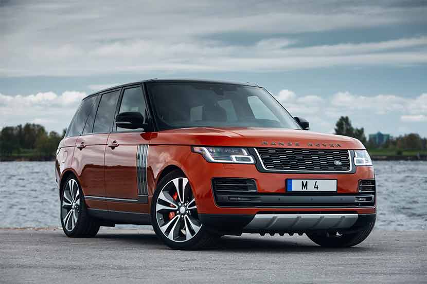 White Range Rover Sport parked on road in front of green park