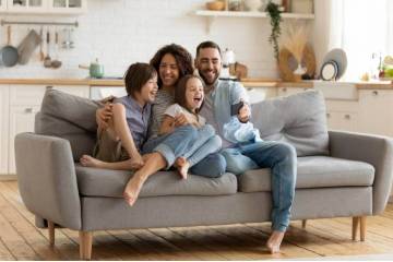Family sitting and laughing on a sofa at home