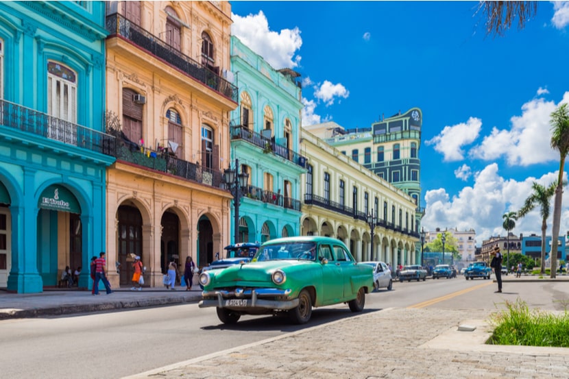 A classic car drives on a road in Cuba 