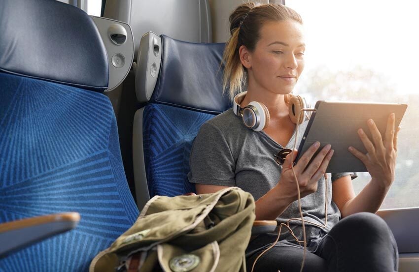 Woman on a plane holding a tablet