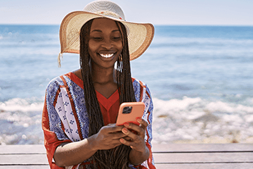 Woman holding a phone at the beach