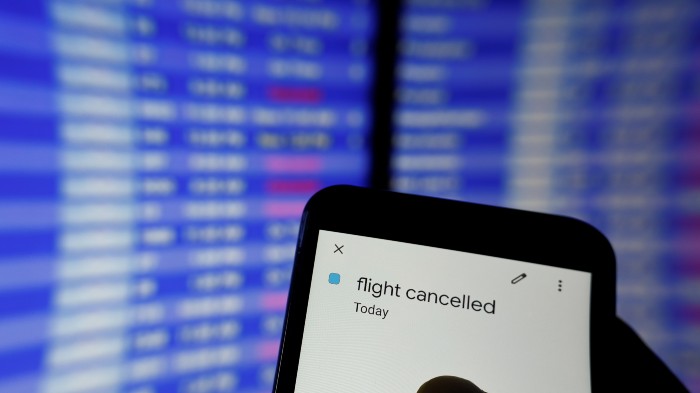 Person holding phone with a 'flight cancelled' message