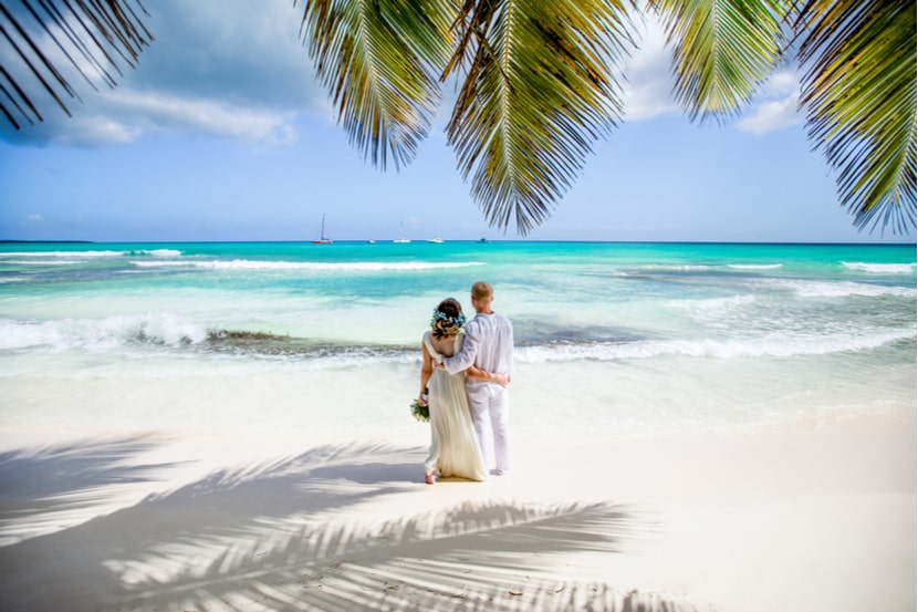 A couple on the beach after just getting married abroad