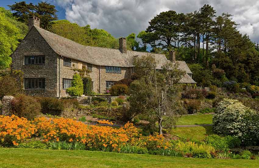 Stately home surrounded by wildflowers and plants 