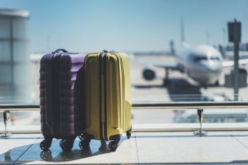 Suitcases with plane behind