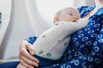 Infant asleep on parent  while on a plane