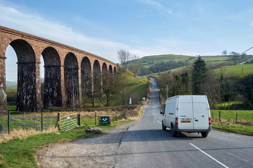 Van driving by a bridge