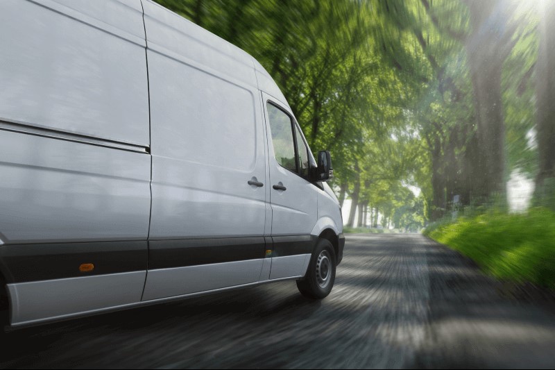 White van travels down road