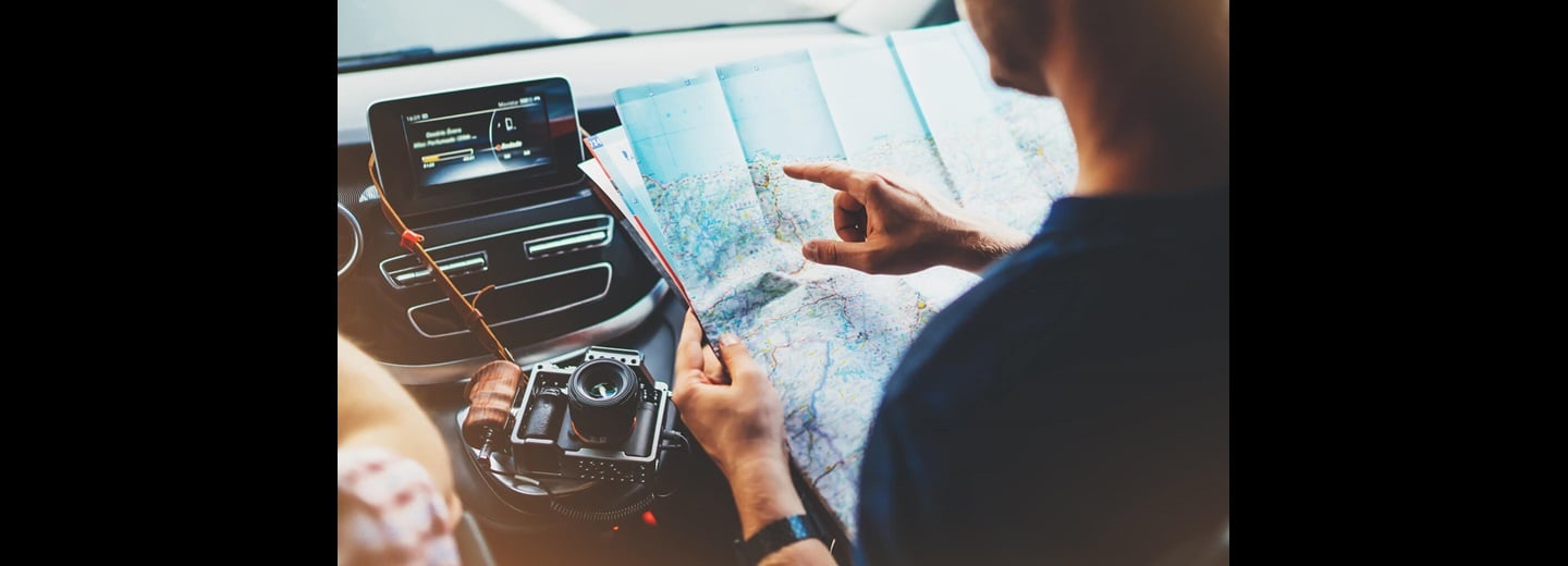 A man looking at a map in his car